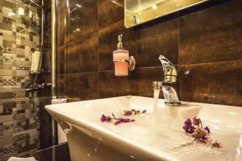 a bathroom with a sink with flowers on it at Semiramis Guesthouse in Adamas