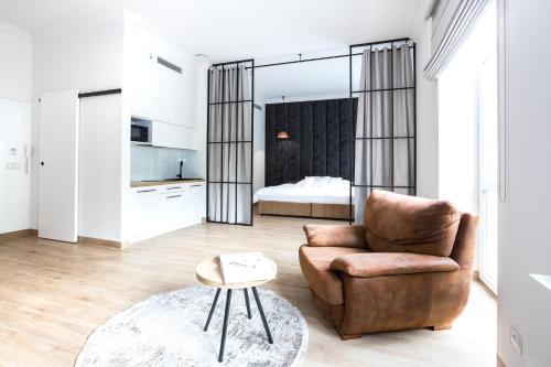 een woonkamer met een stoel en een bed bij Europejski Boutique Hotel in Radom