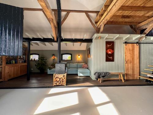 a living room with wooden ceilings and a blue couch at Pleisterplaats Schöppert B&B in Neede