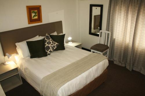 a hotel room with a bed and a chair at The Residence at Villa Wiese in Swakopmund