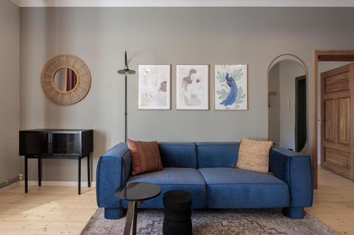 uma sala de estar com um sofá azul e uma televisão em Centra Nams - Center Apartments em Cēsis