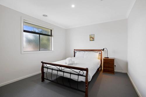 a bedroom with a bed and a window at Modern Pakenham Family Home near Lakeside in Pakenham