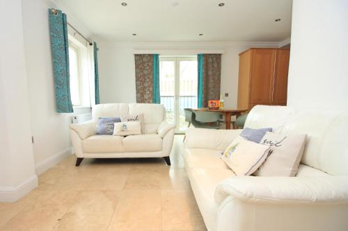 a living room with two white couches and a table at 50m FROM THE BEACH, dogs welcome in St Merryn