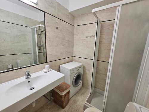 a bathroom with a sink and a washing machine at Appartamento Vista Mare - Spriano in Rio Marina