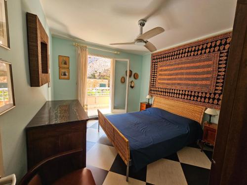 a bedroom with a blue bed and a window at Appartamento Vista Mare - Spriano in Rio Marina