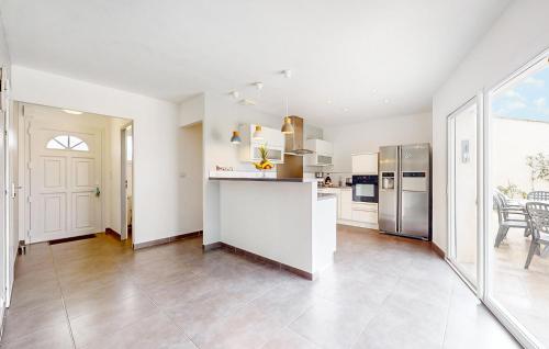 cocina grande con paredes blancas y electrodomésticos de acero inoxidable en Lovely Home In Saint-Georges-De-Didon, en Saint-Georges-de-Didonne