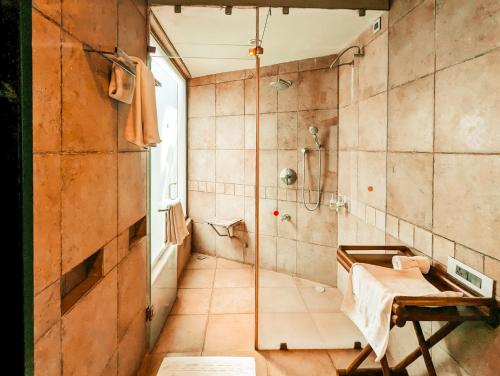 a bathroom with a shower and a bed in it at Waterwoods Lodge Kabini in Begūr