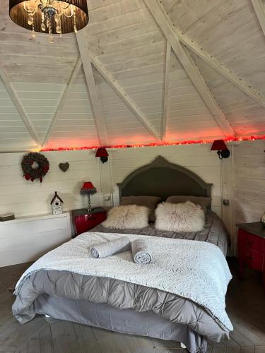 a bedroom with a large bed with red lights at La Naomath - Maison d'hôtes, Hébergement insolite & Gîte in Bayeux