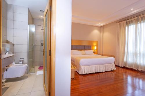 MeruThree Steers Hotel的一间带床和浴室的酒店房间