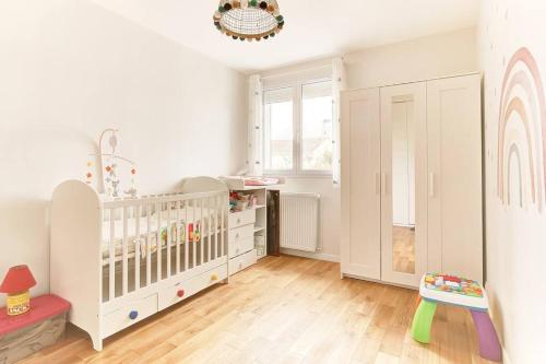 a baby room with a crib and a window at Villa Les Fleurs in Montigny-le-Bretonneux