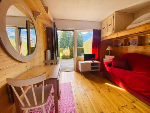 un salon avec un canapé rouge et un miroir dans l'établissement Nouveau Studio Rénové Grande Terrasse, à Samoëns