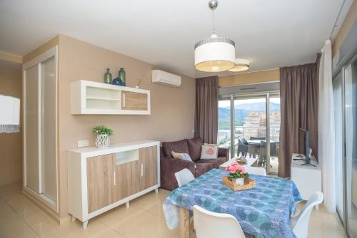 a living room with a table and a couch at Holiday Deluxe Apartment Miramar Magic World in Oropesa del Mar