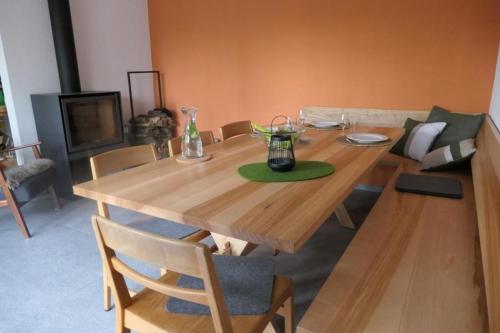 einen Holztisch im Wohnzimmer mit einem Tisch und Stühlen in der Unterkunft La Pineta in Locarno