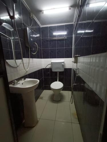 a bathroom with a toilet and a sink at Manja Inn, Paka in Paka
