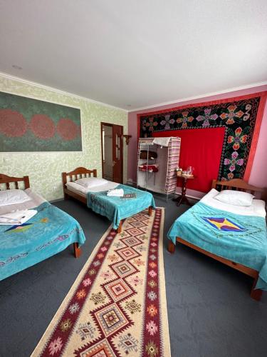 a room with two beds and a rug at Guest House Emily in Bokonbayevo