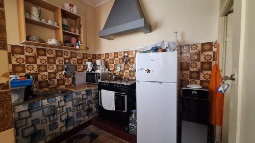eine Küche mit einem weißen Kühlschrank und einem Herd in der Unterkunft Casa de Férias in Tarrafal