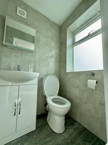 ein Badezimmer mit Toilette und Waschbecken und einem Fenster in der Unterkunft Flat on high street in Saltdean