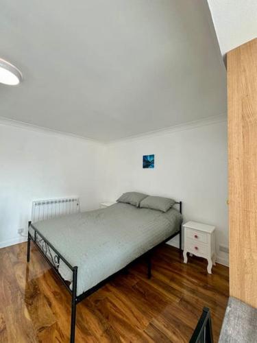 ein Schlafzimmer mit einem Bett und einer weißen Wand in der Unterkunft Flat on high street in Saltdean