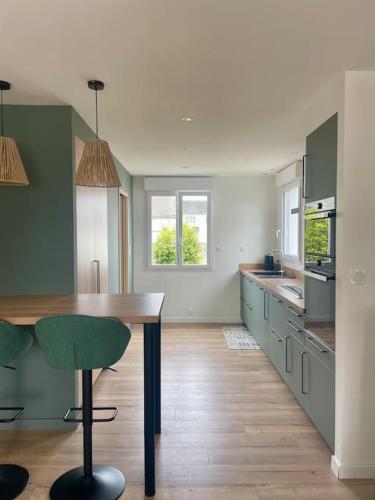 une cuisine avec une table et une chaise verte dans l'établissement -Ty Léodele- maison Concarneau, à Concarneau
