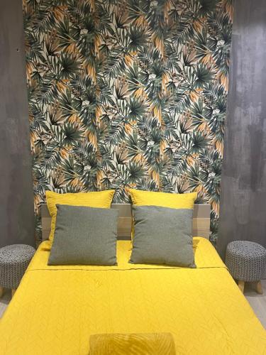 - une chambre avec un lit jaune et un mur fleuri dans l'établissement Chez fati, à Paris