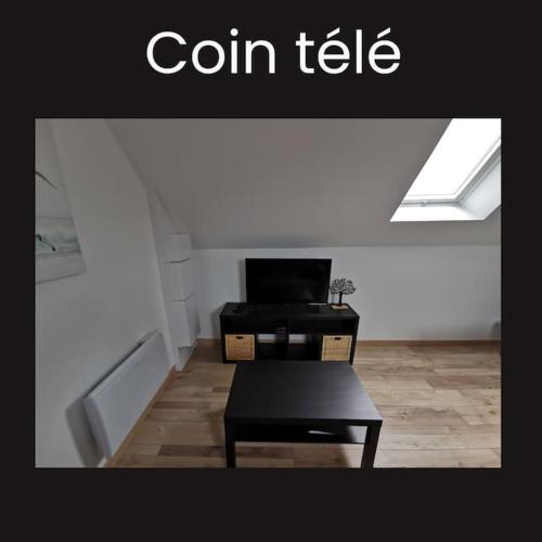 a living room with a table and a roof at * Ty cocon * wifi * parking * moderne * in Melgven