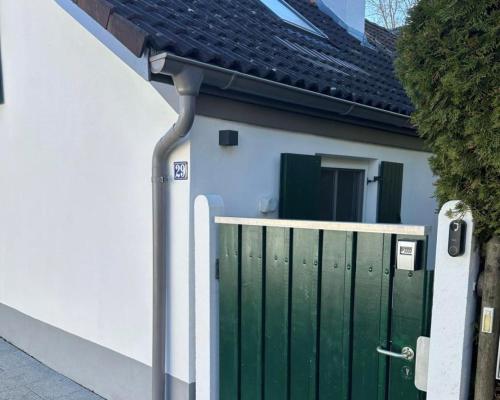 a house with a green gate in front of it at Fischerhaus Hermine in Dießen am Ammersee