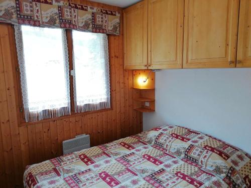 a bedroom with a bed and two windows at Appartement Le Grand-Bornand, 2 pièces, 5 personnes - FR-1-241-164 in Le Grand-Bornand