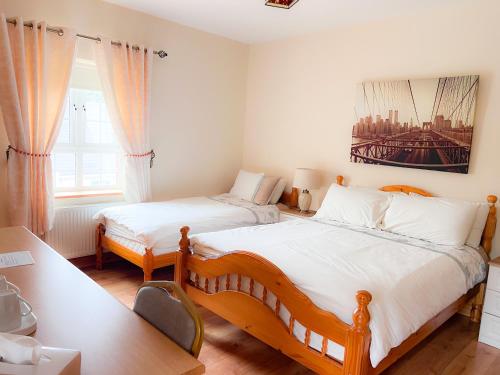 a bedroom with two twin beds and a desk and a desk at Kilcar Lodge in Kilcar