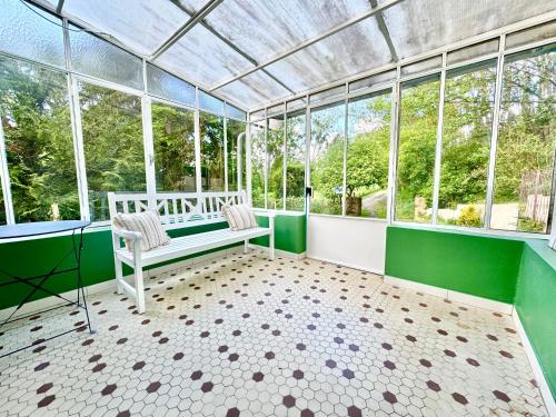 - une véranda avec un banc dans une chambre dotée de fenêtres dans l'établissement 2 Maisons - Le Tranquille - Jardin - Terrasse - BBQ, au Mans