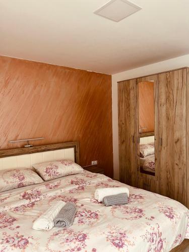 a bedroom with a bed with a floral bedspread at Zeleni Dvor in Ribarska Banja