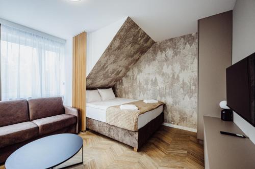 a small bedroom with a bed and a couch at Luksusowe apartamenty przyjazne dla rodzin - zwierzęta akceptowane - budynek A in Podgórzyn