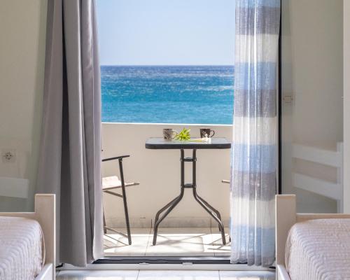 a table in a room with a view of the ocean at Giant Woman in Tsoútsouros