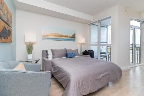 a bedroom with a bed and a couch at Sunlit Urban Charm In Old Town Victoria in Victoria