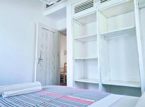 a bedroom with a bed with white shelves at 2 Bedroom Holiday Cottages Bofa Road, Kilifi in Kilifi