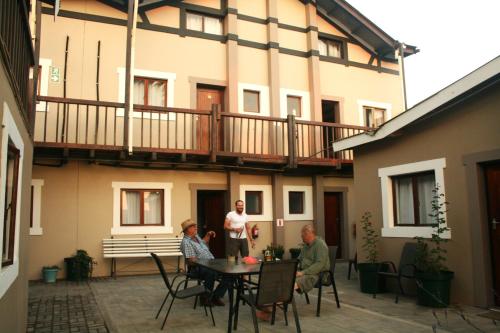 The Residence at Villa Wiese في سواكوبموند: ثلاثة أشخاص يجلسون حول طاولة أمام المبنى