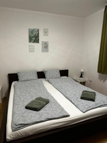 Una cama con dos almohadas verdes encima. en BükkRoseHill, en Bükkmogyorósd