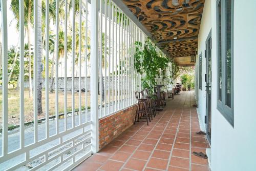 a corridor of a building with chairs and windows at Gem’s House in Mui Ne