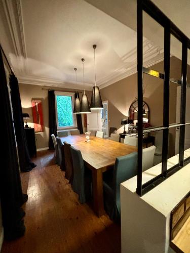 une salle à manger avec une table et des chaises en bois dans l'établissement Demeure Arcachonaise de charme, à Arcachon
