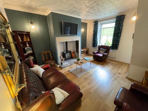 sala de estar con sofá y chimenea en Acacia House, en Wolsingham