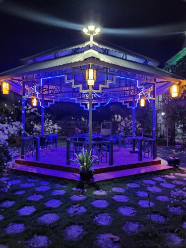 a gazebo lit up at night with purple lights at Gem’s House in Mui Ne