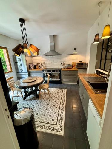 une cuisine avec une table et une salle à manger dans l'établissement Demeure Arcachonaise de charme, à Arcachon