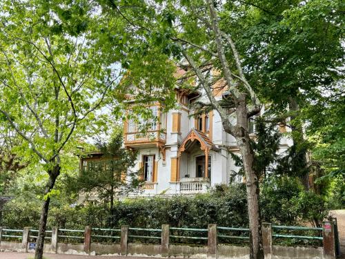 an old house with a fence in front of it at Demeure Arcachonaise de charme in Arcachon