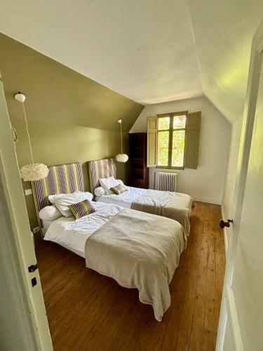 une chambre avec deux lits et une fenêtre dans l'établissement Demeure Arcachonaise de charme, à Arcachon