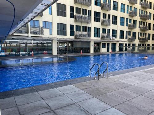 una gran piscina frente a un edificio en KK Homestay City Deluxe room - Ming Garden Hotel & Residence, en Kota Kinabalu
