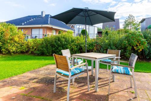 una mesa y sillas con una sombrilla en un patio en Ferienwohnung Johanna EG en Wohlenberg
