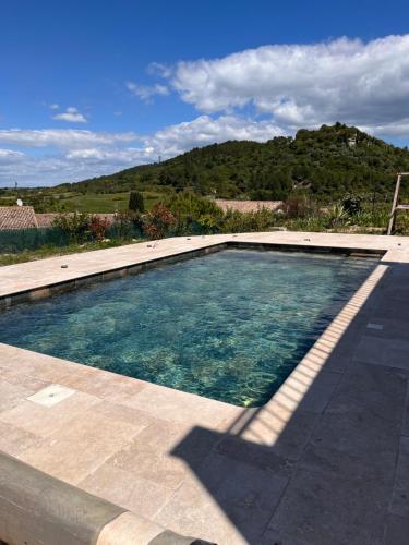 - une piscine d'eau bleue sur une terrasse dans l'établissement Villa à Montmirat, à Montmirat