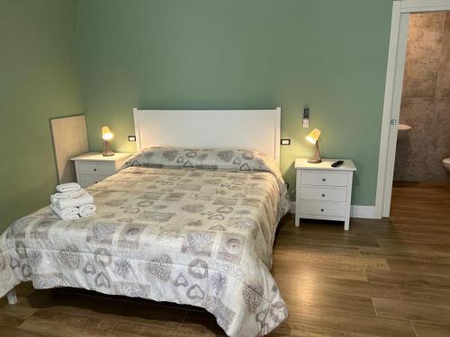 a bedroom with a bed with two night stands and two lamps at RoMa Apartment & Room in Canosa di Puglia