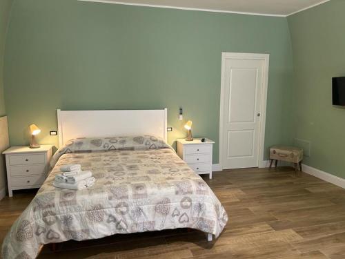 a bedroom with a large bed and two night stands at RoMa Apartment & Room in Canosa di Puglia