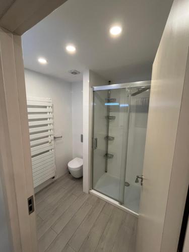 a bathroom with a glass shower and a toilet at Orbi sea towers in Batumi