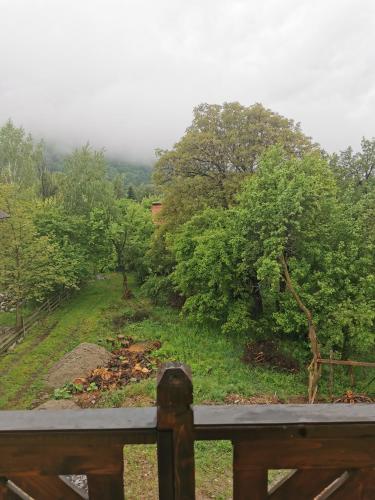 a view of a field with trees and a fence at Yellow House in Bran